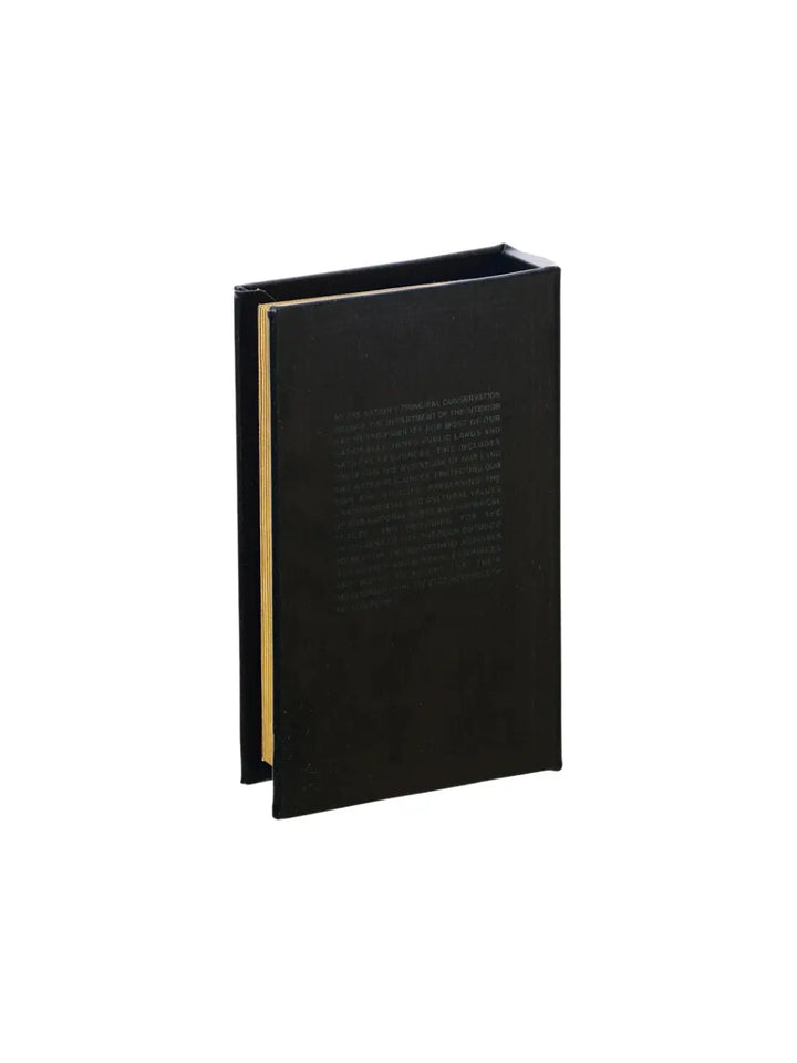 The back cover of the Book Box - Concrete Manual BK from Puebco features realistic embossed paragraphs of vintage government text against a textured black finish | Twentyseven Toronto
