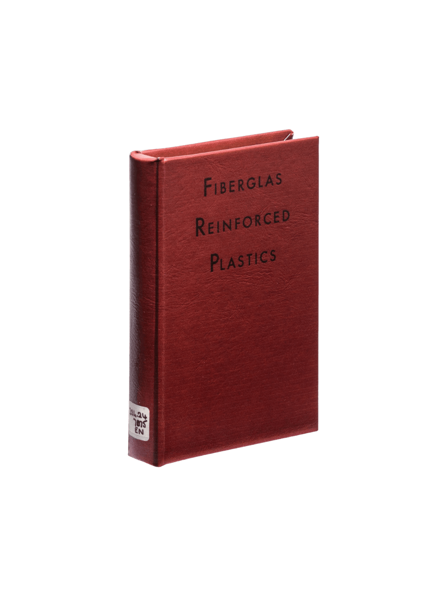 A front view of the red Book Box - Fiberglass Plastics from Puebco standing upright with black ink and a white library classification label on the bottom spine | Twentyseven Toronto