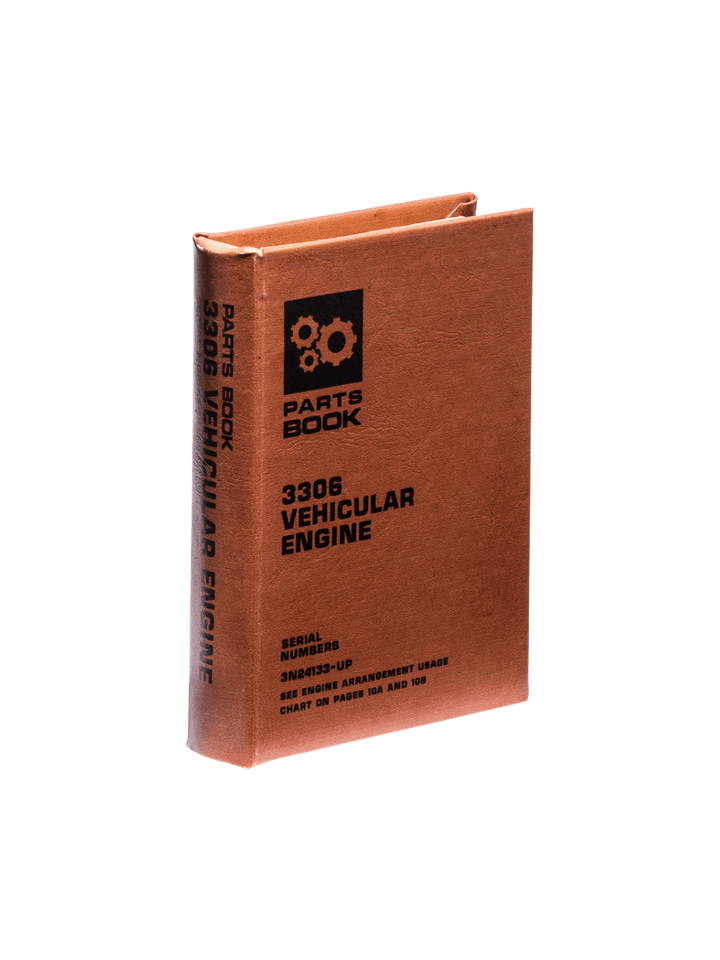 Brown Book Box - Vehicular Engine from Puebco stands upright, showcasing its vintage gear graphic and technical text printed on the front and spine | Twentyseven Toronto