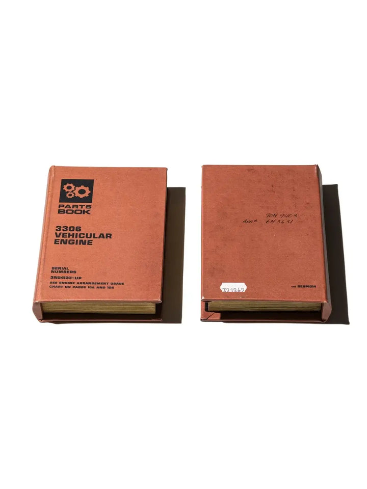 Two brown industrial-style Book Box - Vehicular Engine from Puebco organizers are laid flat, showcasing the "Parts Book" graphic on the front cover and handwritten catalog numbers on the back cover | Twentyseven Toronto