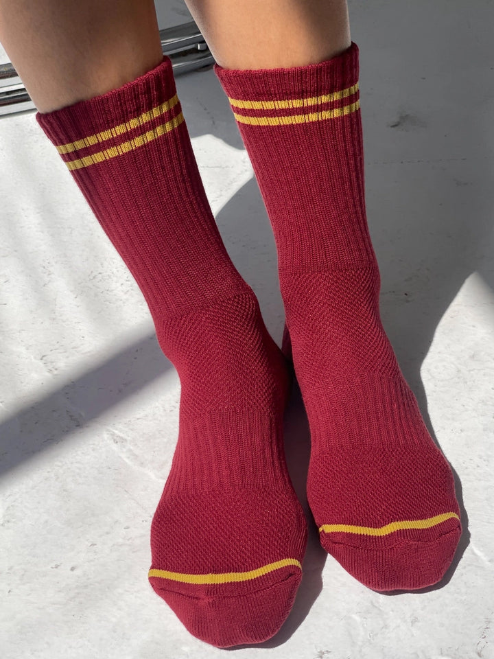 Le Bon Shoppe Boyfriend Socks in Cardinal red with contrasting golden yellow stripes, shown worn in a sunlit lifestyle view | Twentyseven Toronto