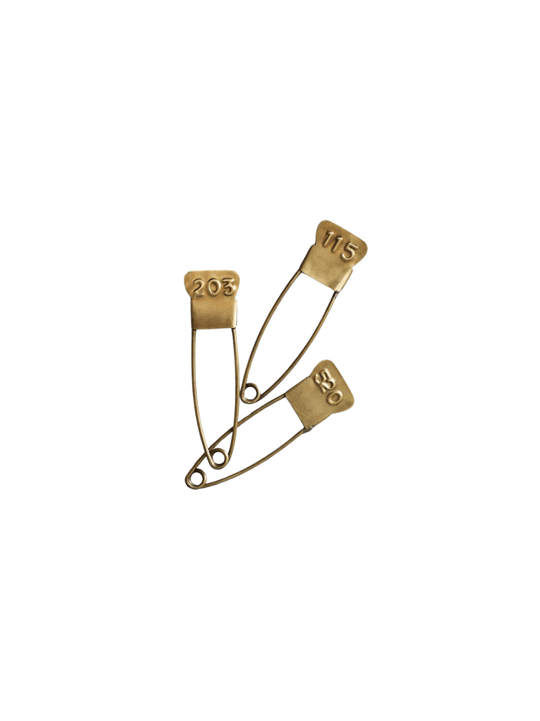 A set of three vintage-inspired Brass Number Pin from Fog Linen Work fasteners, displaying different three-digit codes on their antique-style heads | Twentyseven Toronto