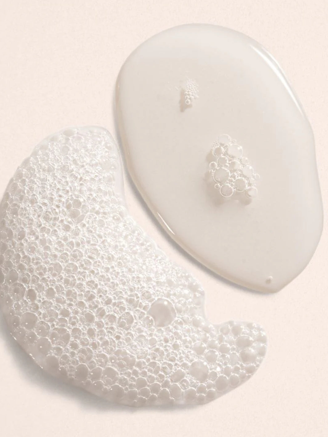 Two white foamy product drops of Beauty from Bees bubble bath in Eucalyptus on a light pink background | Twentyseven Toronto