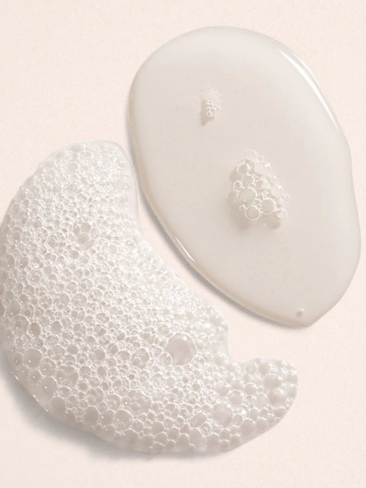 Two white foamy product drops of Beauty from Bees bubble bath in Eucalyptus on a light pink background | Twentyseven Toronto