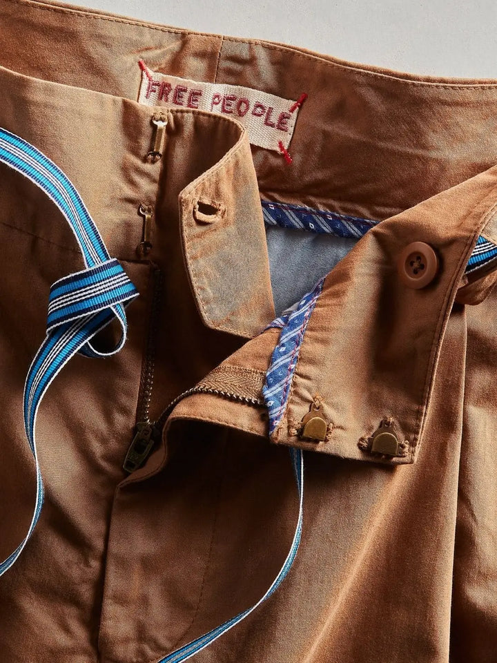 An open detail shot focuses on the interior lining pattern, zipper fly, and metal clasp closures of the Free People Buckle Back Trousers - Tobacco Combo | Twentyseven Toronto