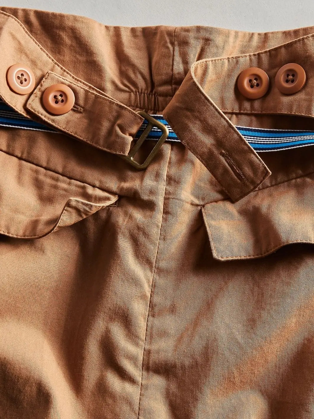 A close-up view of the back waistband highlights the adjustable tab detailing with buttons and a brass slide on the Free People Buckle Back Trousers - Tobacco Combo | Twentyseven Toronto