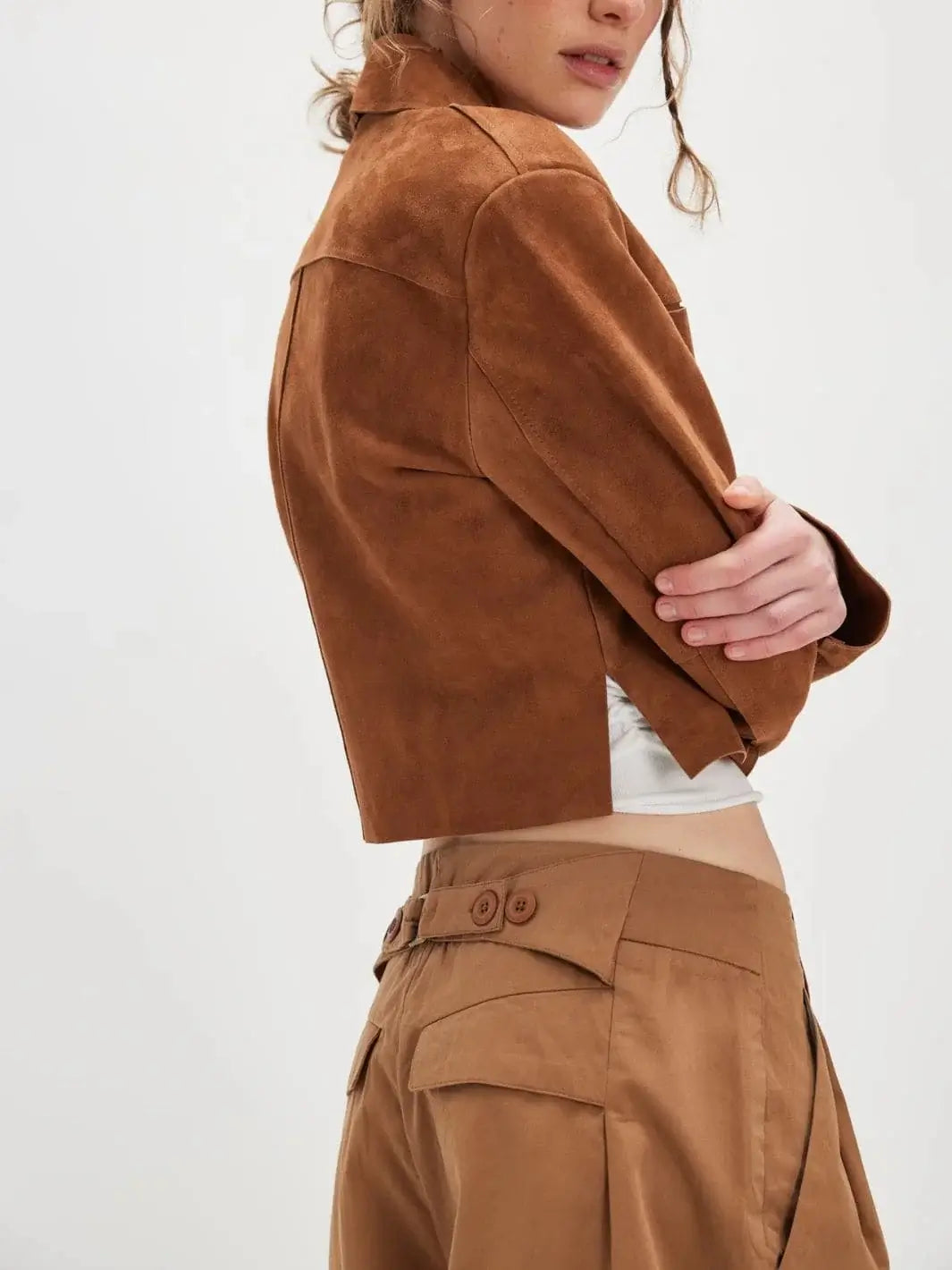 Side profile shot emphasizes the structured waist construction and rear button-tab accents of the Free People Buckle Back Trousers - Tobacco Combo | Twentyseven Toronto