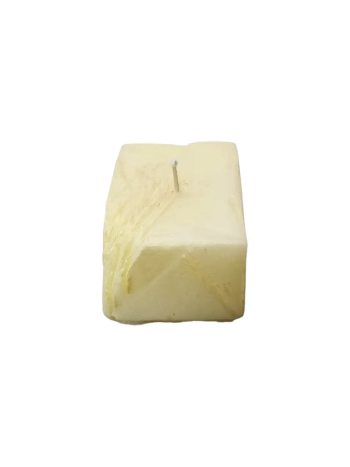 Candle in the shape of a block of butter from Cereria Introna on a white background | Twentyseven Toronto