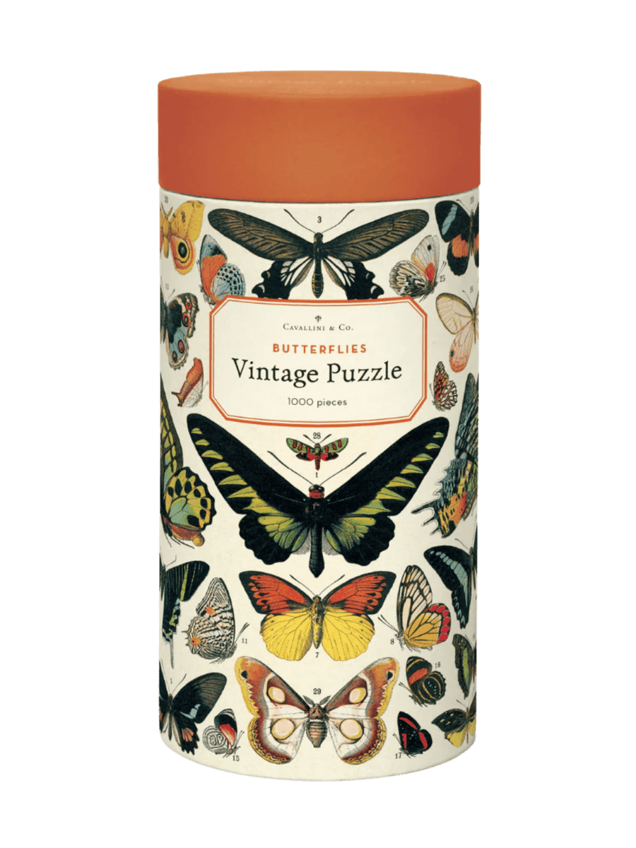 Cylindrical paper tube for the Cavallini Paper & Co Butterflies 1000 Piece Puzzle with an orange cap, highlighting a central "Vintage Puzzle" title card surrounded by vibrant butterfly graphics | Twentyseven Toronto