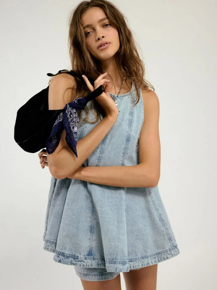 A medium close-up shot emphasizes the model holding a black shoulder bag with a blue bandana accent alongside the Free People Cassius Denim Set in Bleachout | Twentyseven Toronto