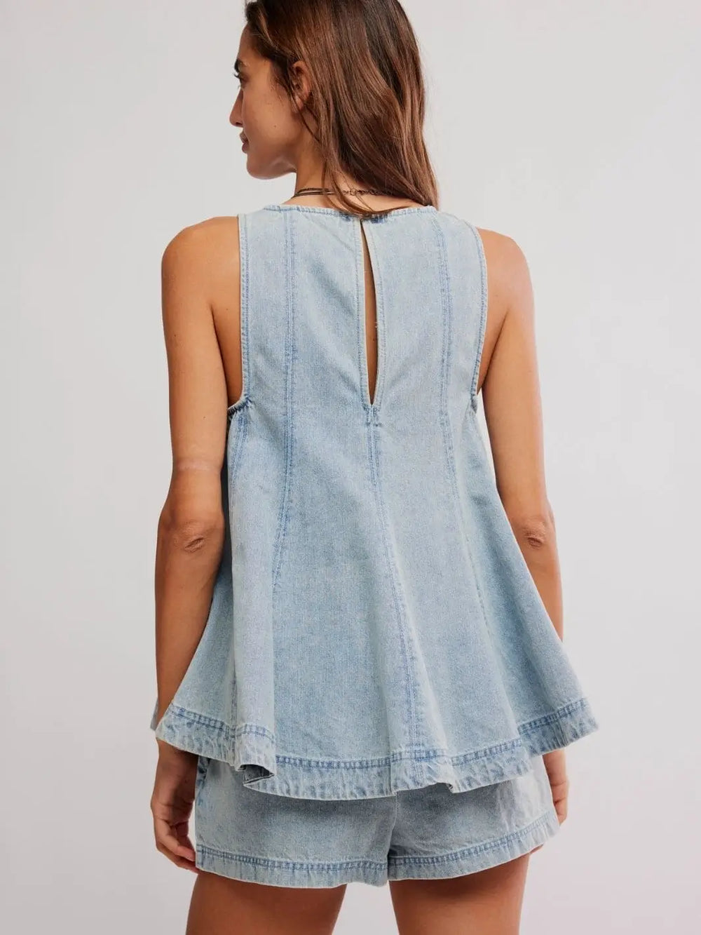 A full rear perspective captures the structured panels, flared high-low silhouette, and keyhole detailing of the Free People Cassius Denim Set in Bleachout | Twentyseven Toronto