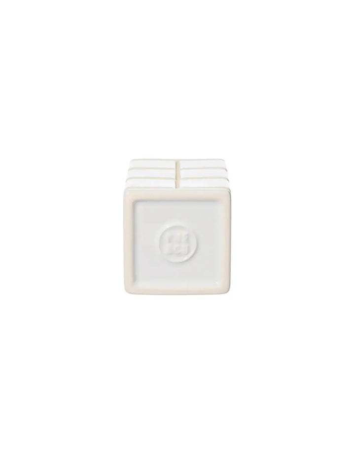 The square underside of the white Ceramic Bath Ensemble / Toothbrush Stand from Puebco, showcasing its clean edges and a circular debossed brand logo in the centre | Twentyseven Toronto