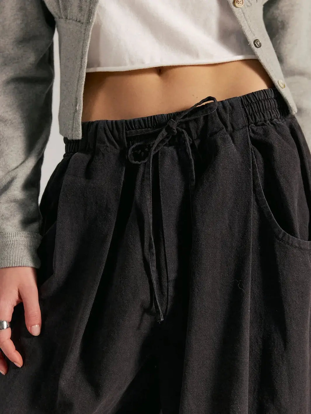 A close-up front view highlights the elastic drawstring waistband and slouchy front pockets of the Free People Chambers Laidback Pull-On Pants in Black | Twentyseven Toronto