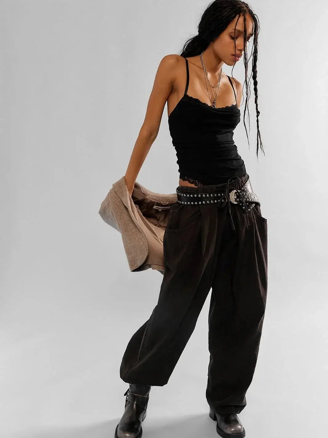 A full-length shot showcases a model wearing the Free People Chambers Laidback Pull-On Pants in Black styled with a black camisole, a slouchy blazer, and a studded leather belt | Twentyseven Toronto