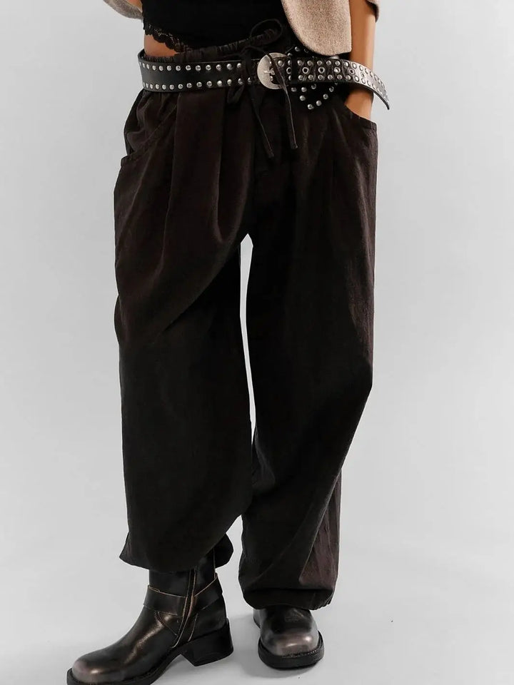 A mid-shot focuses on the low-slung styling and oversized, slouchy silhouette of the Free People Chambers Laidback Pull-On Pants in Black paired with dark leather boots | Twentyseven Toronto
