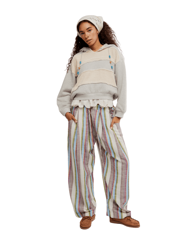 Woman wearing a light-colored hoodie and striped 'Chambers Laid Back Stripe Pants' in 'Ivory Combo' from Free People on a transparent background | Twentyseven Toronto