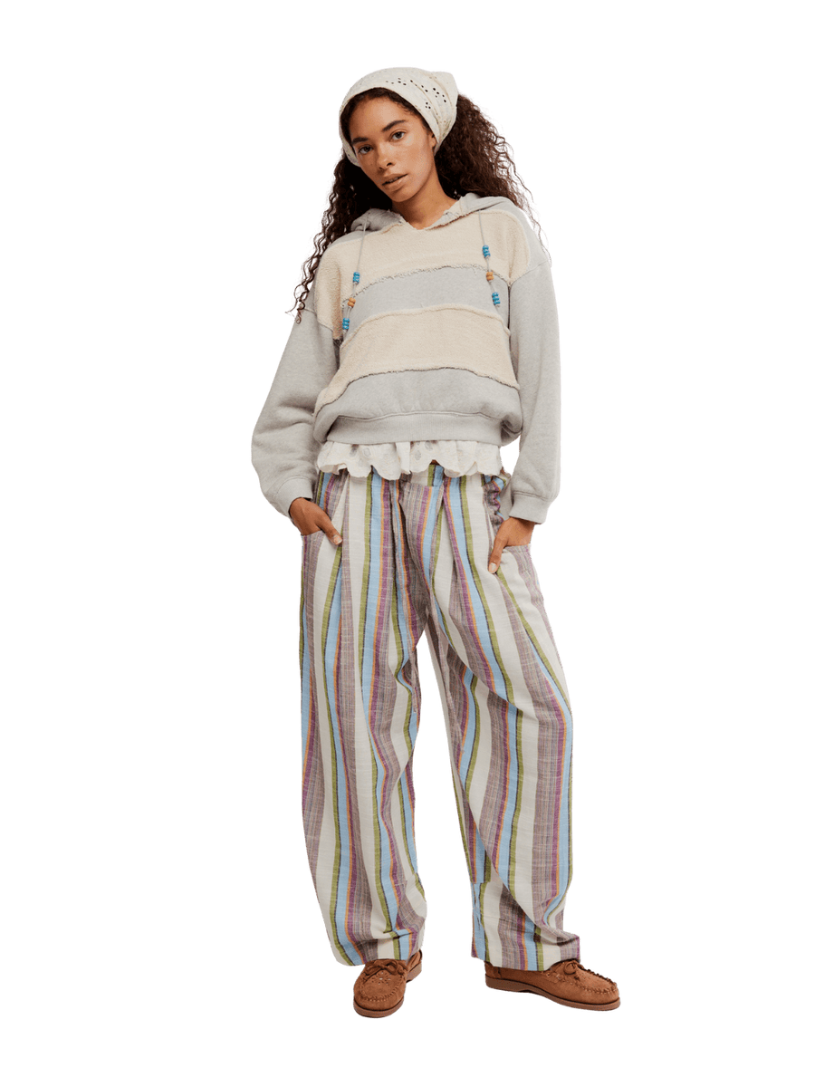 Woman wearing a light-colored hoodie and striped 'Chambers Laid Back Stripe Pants' in 'Ivory Combo' from Free People on a transparent background | Twentyseven Toronto