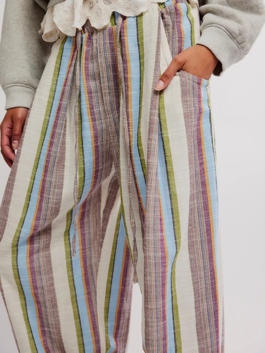 Close up details of 'Chambers Laid Back Stripe Pants' in 'Ivory Combo' with hand in pocket from Free People on a white background | Twentyseven Toronto