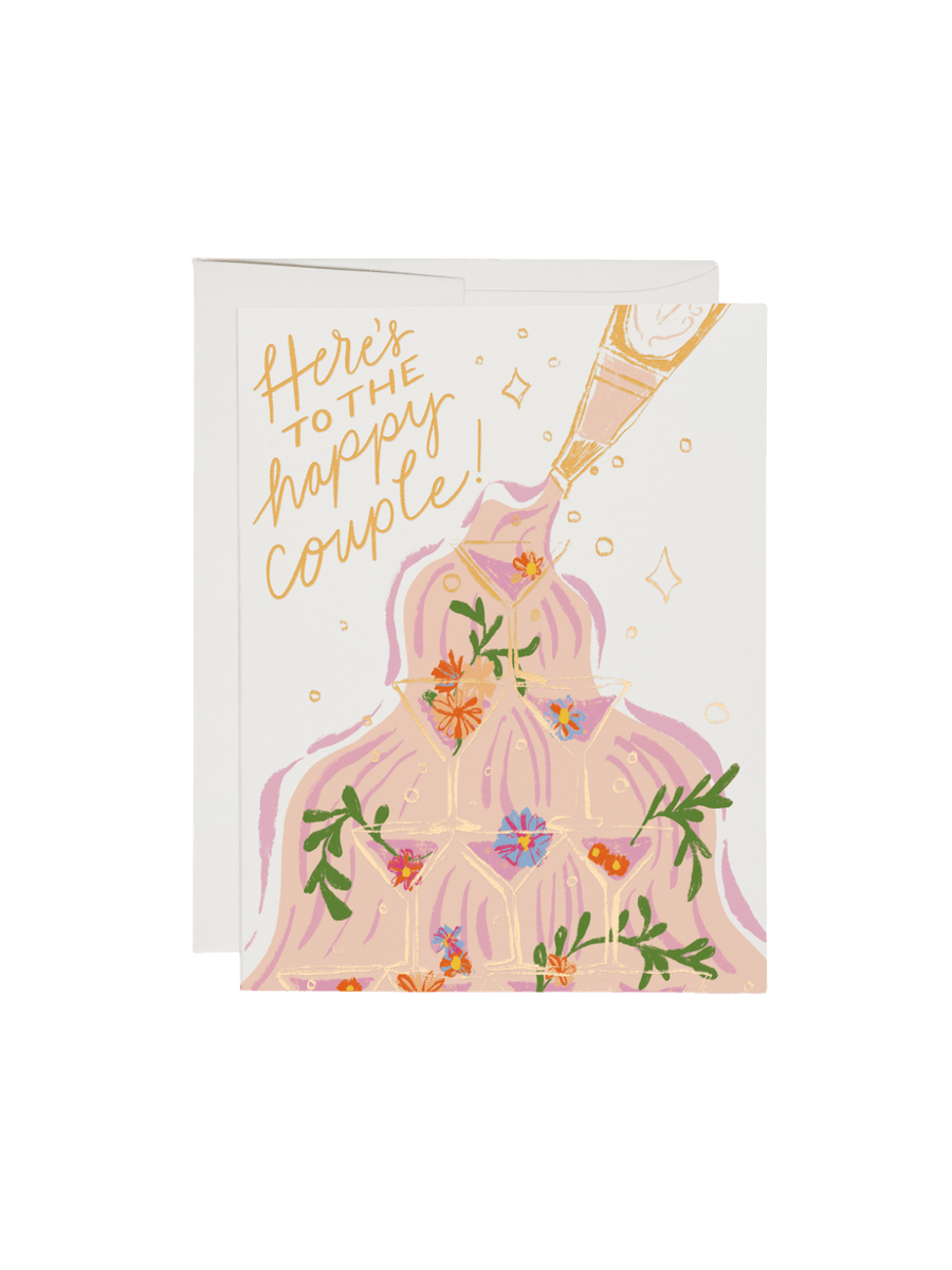 Greeting card from Red Cap Cards with a bride and groom illustration and 'Here's to the happy couple!' text on a white background | Twentyseven Toronto