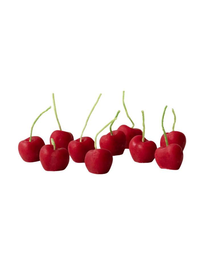 Red cherry-shaped beeswax candles from Happy Organics on a transparent background | Twentyseven Toronto