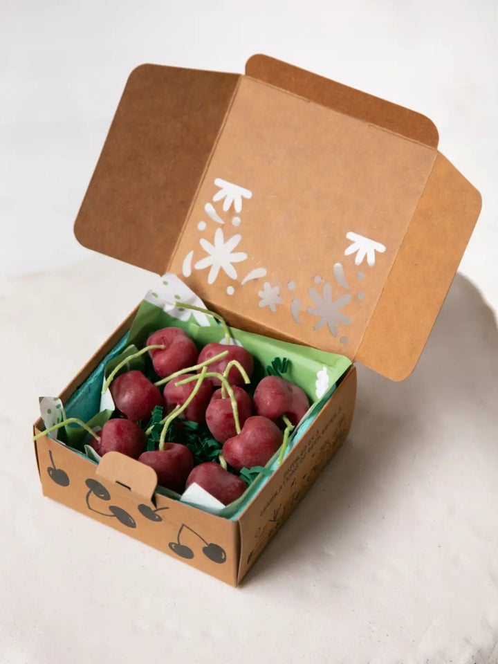 Box of cherry shaped candles from Happy Organics in brown packaging on a white background | Twentyseven Toronto