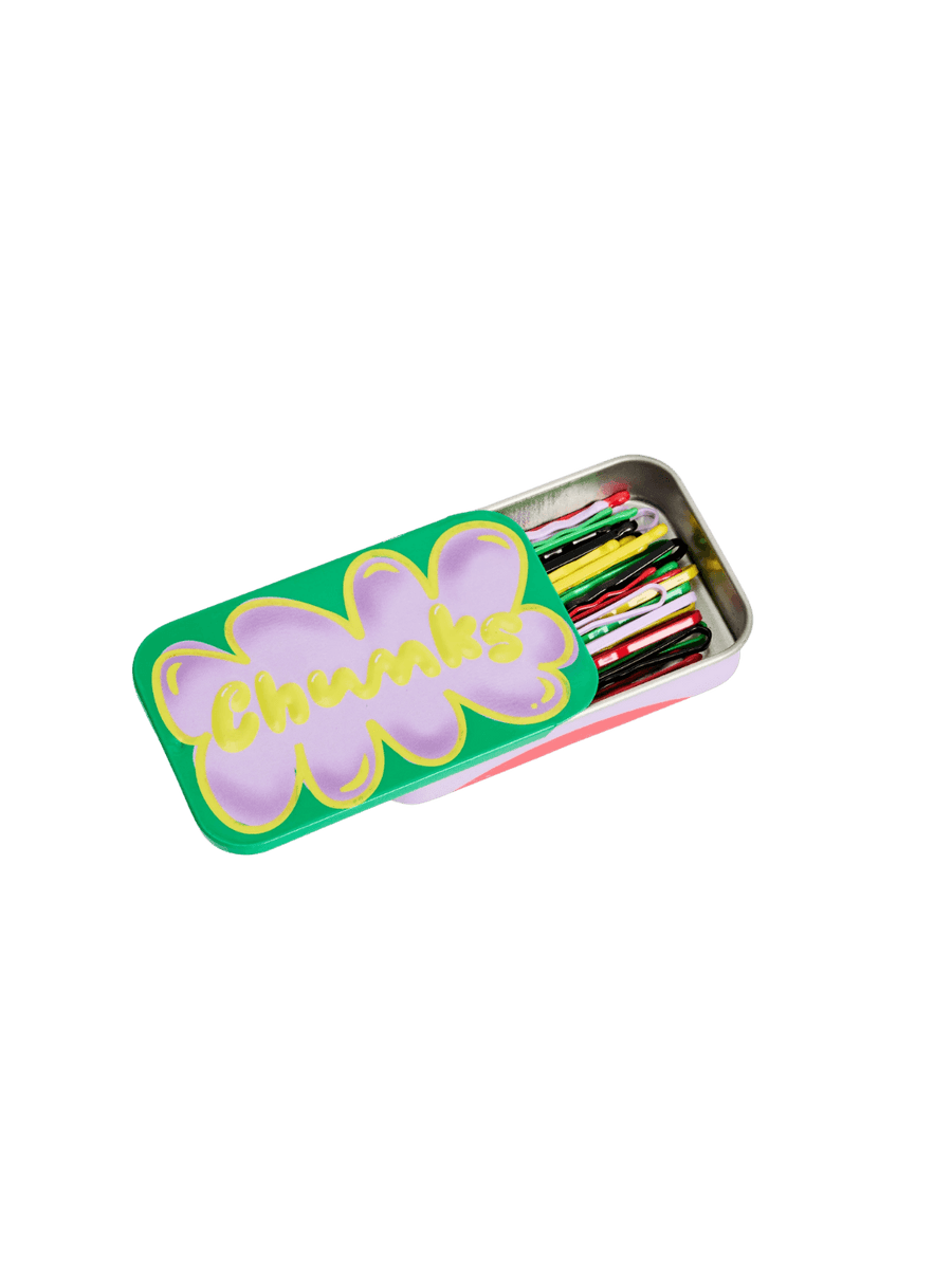 A vibrant green storage tin with a purple cloud design and the word Chunks is shown partially slid open to display a collection of multi-colored Chunks Hairclips Chunks Bobby Pins inside | Twentyseven Toronto