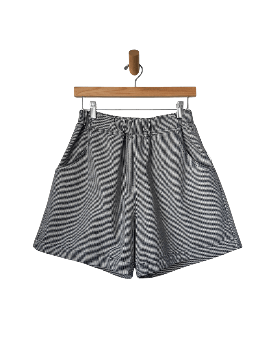 Le Bon Shoppe City Shorts in 'Blue Stripe' on a wooden hanger against a transparent background | Twentyseven Toronto