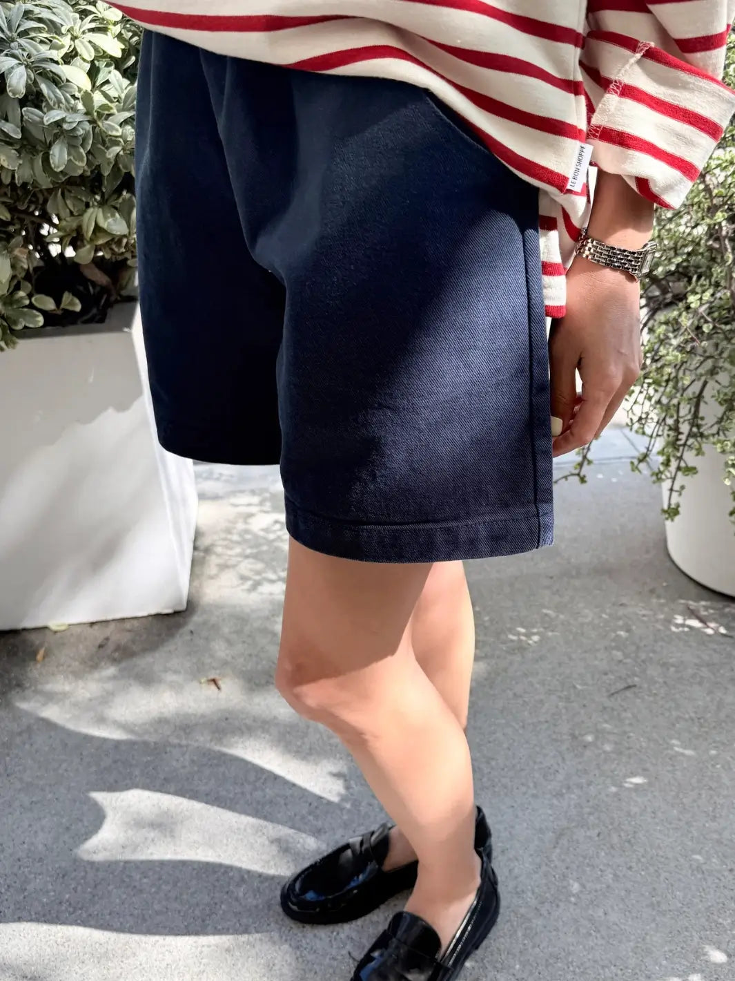 Person wearing navy 'City Shorts' and a red and white striped shirt from Le Bon Shoppe outdoors | Twentyseven Toronto