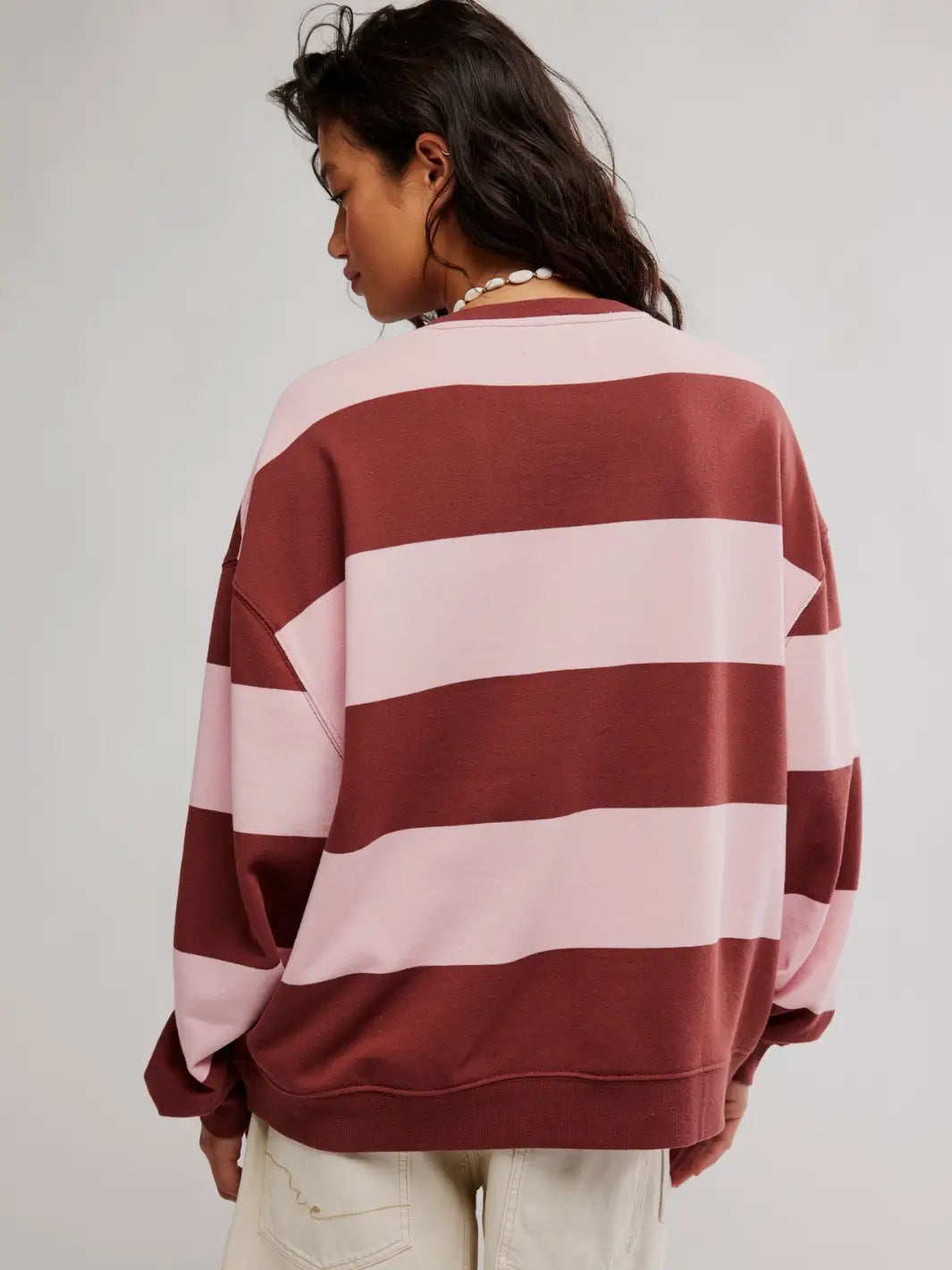 A rear view showcases the wide horizontal pink and burgundy bands across the back of the Free People Classic Stripe Crew Wide in Strawberry Wine Combo pullover | Twentyseven Toronto