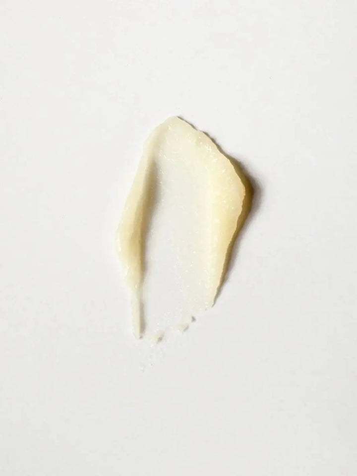 A single, smooth swatch of the creamy Dedcool Coconut Milk Balm Stick is spread over a solid white background | Twentyseven Toronto