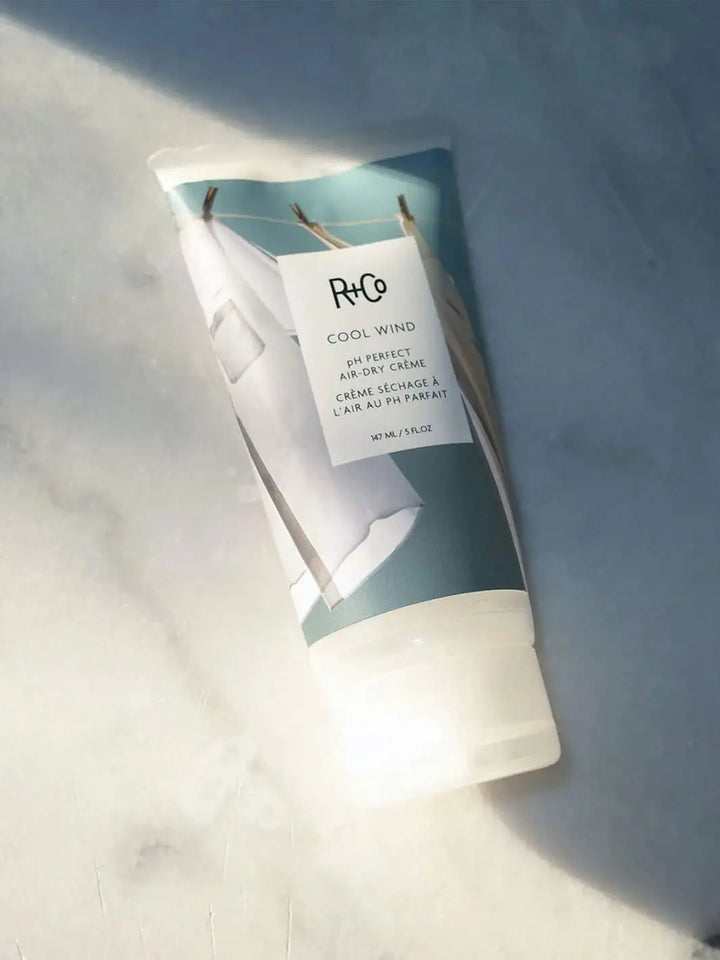 R+Co 'COOL WIND pH Perfect Air Dry Creme' hair product packaging on marble background, 147ml | Twentyseven Toronto