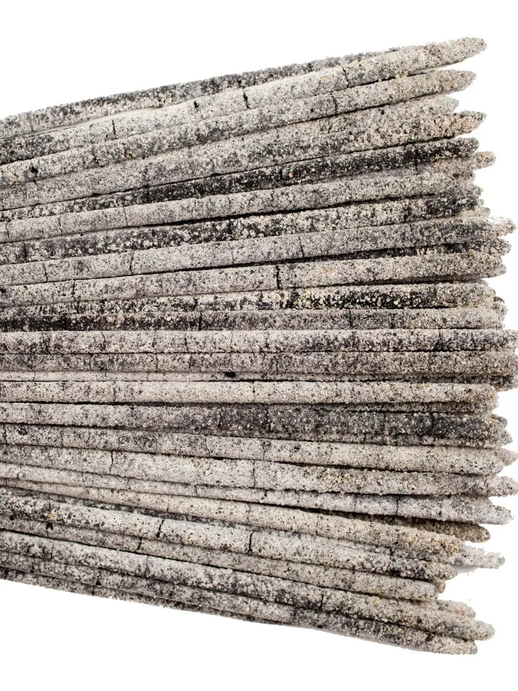 A close-up horizontal view displaying the granular texture of multiple Amae Incense Copal Incense Sticks - Mayan Copal layered together against a white background | Twentyseven Toronto