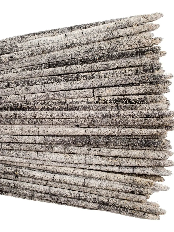 A close-up horizontal view displaying the granular texture of multiple Amae Incense Copal Incense Sticks - Mayan Copal layered together against a white background | Twentyseven Toronto