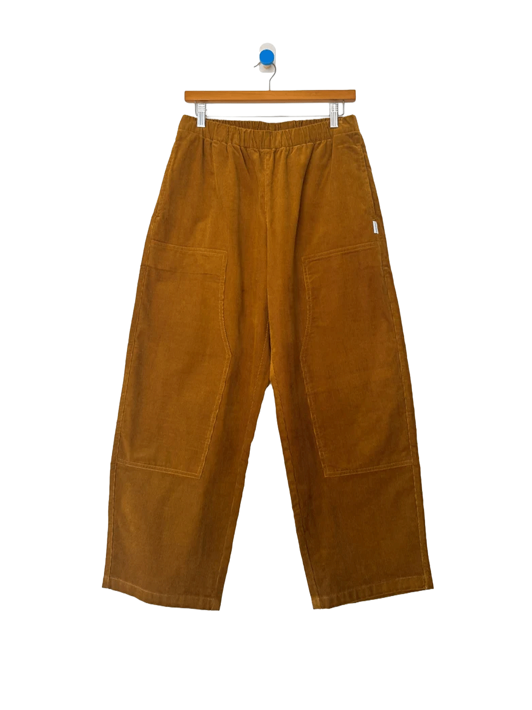 Le Bon Shoppe Corduroy Gardener's Pants in Whiskey on a wooden hanger against a white background, featuring an elastic waistband, oversized front patch pockets and relaxed tapered legs | Twentyseven Toronto