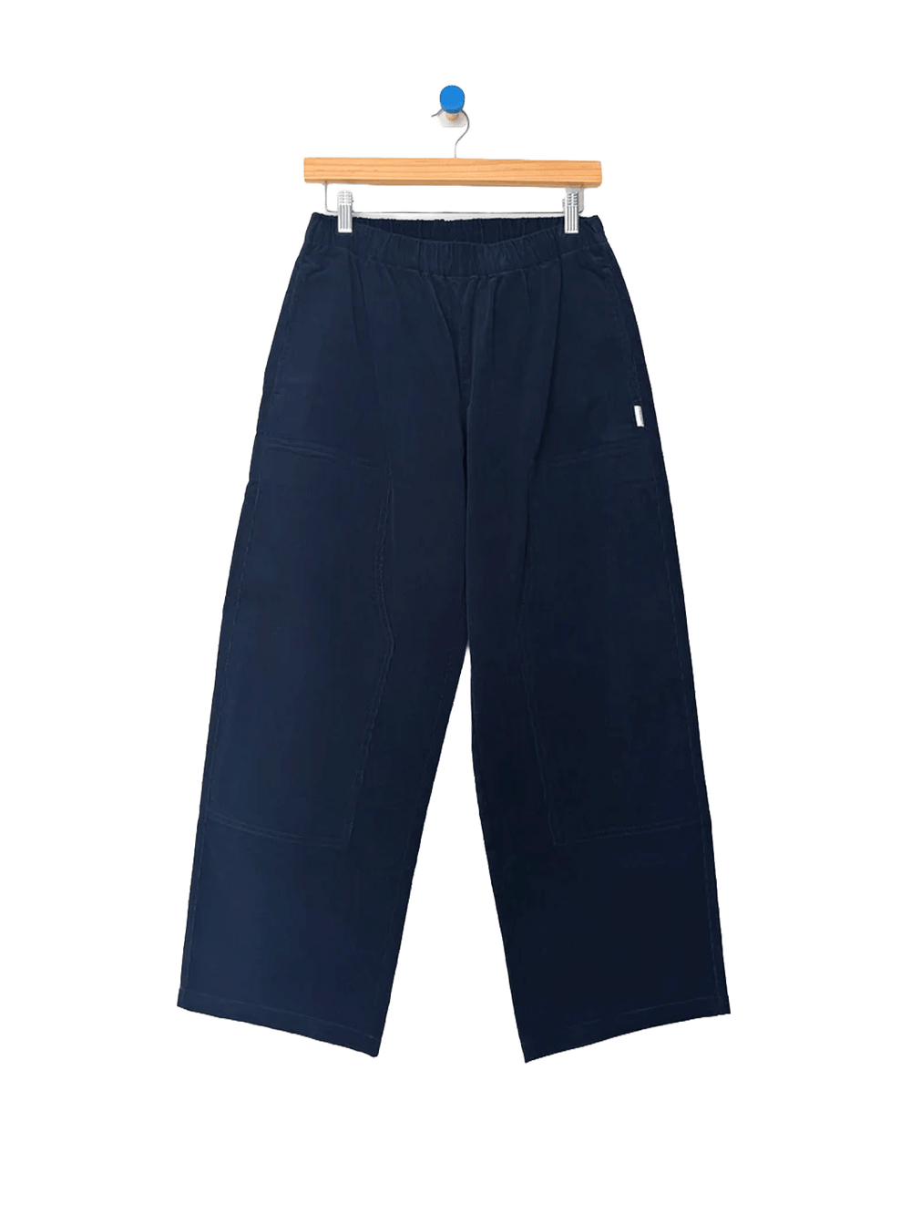 Le Bon Shoppe Corduroy Gardener's Pants in navy on a wooden hanger, featuring an elastic waistband, relaxed tapered legs and carpenter-inspired patch pockets | Twentyseven Toronto