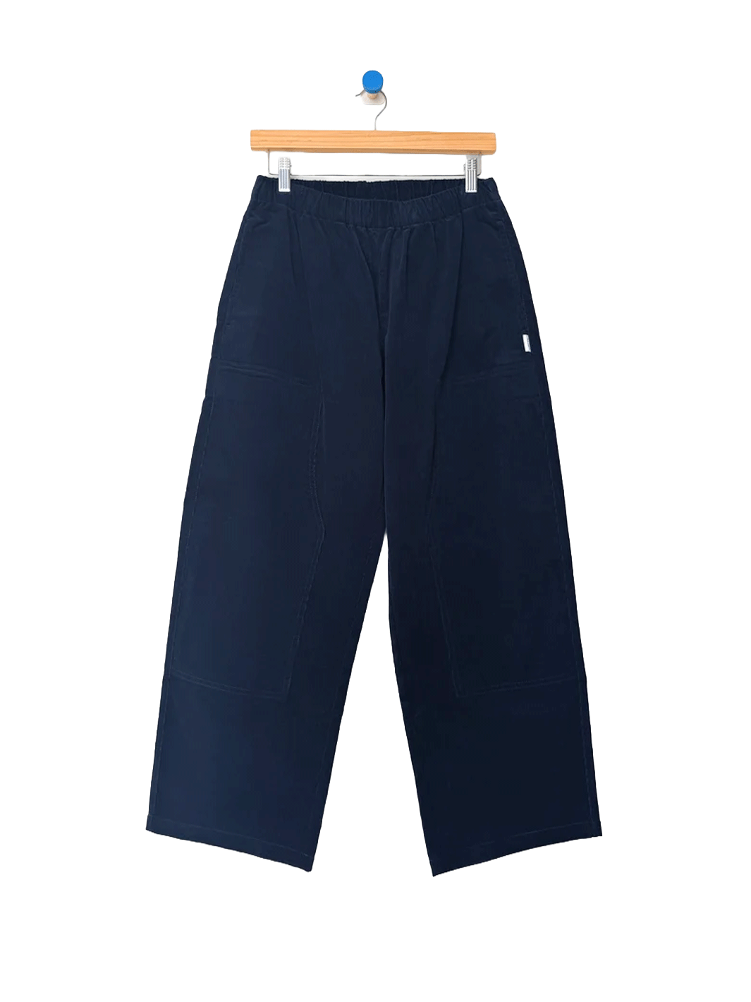 Le Bon Shoppe Corduroy Gardener's Pants in navy on a wooden hanger, featuring an elastic waistband, relaxed tapered legs and carpenter-inspired patch pockets | Twentyseven Toronto