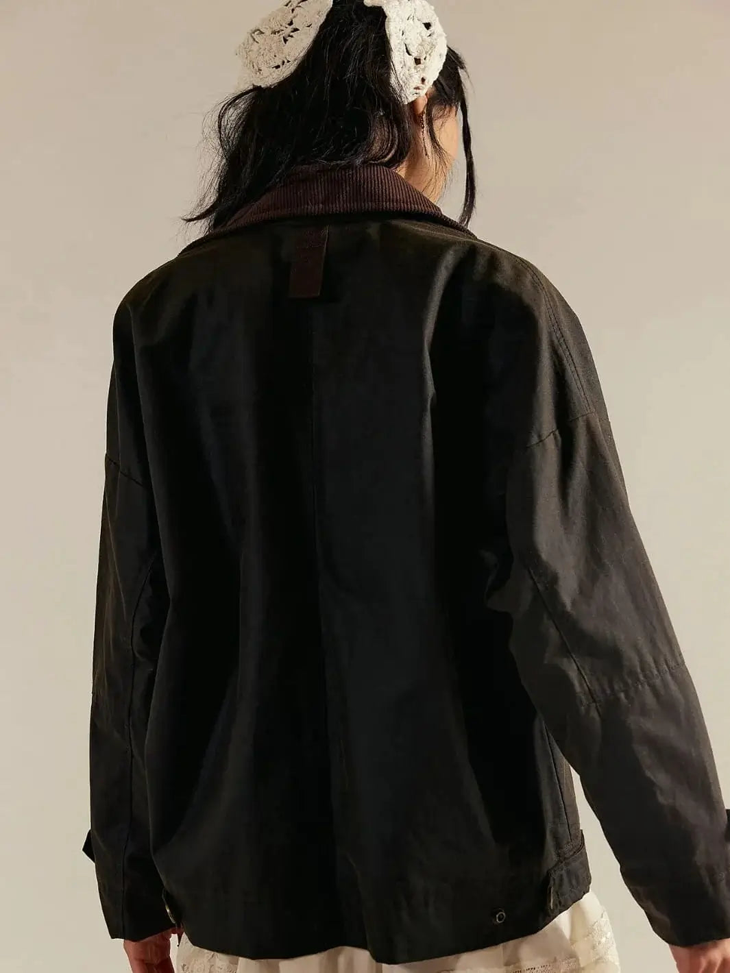 A rear view focuses on the brown corduroy collar and textured fabric backing of the Free People Cori Waxed Jacket in Olive | Twentyseven Toronto