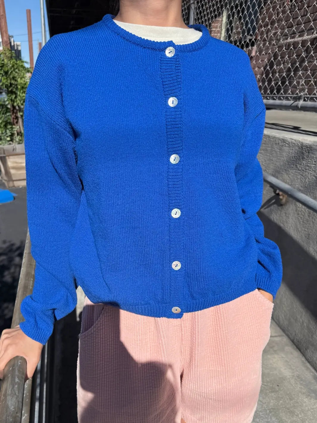 Person wearing a blue 'Cotton Leila Cardigan' in 'Cobalt' from Le Bon Shoppe in an outdoor setting | Twentyseven Toronto