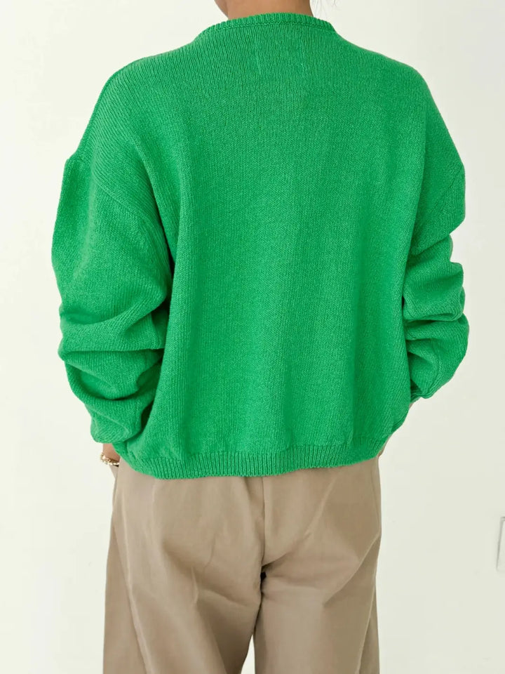 Back view of person wearing a green 'Cotton Leila Cardigan' in 'Spring Green' with beige pants from Le Bon Shoppe on a white background | Twentyseven Toronto