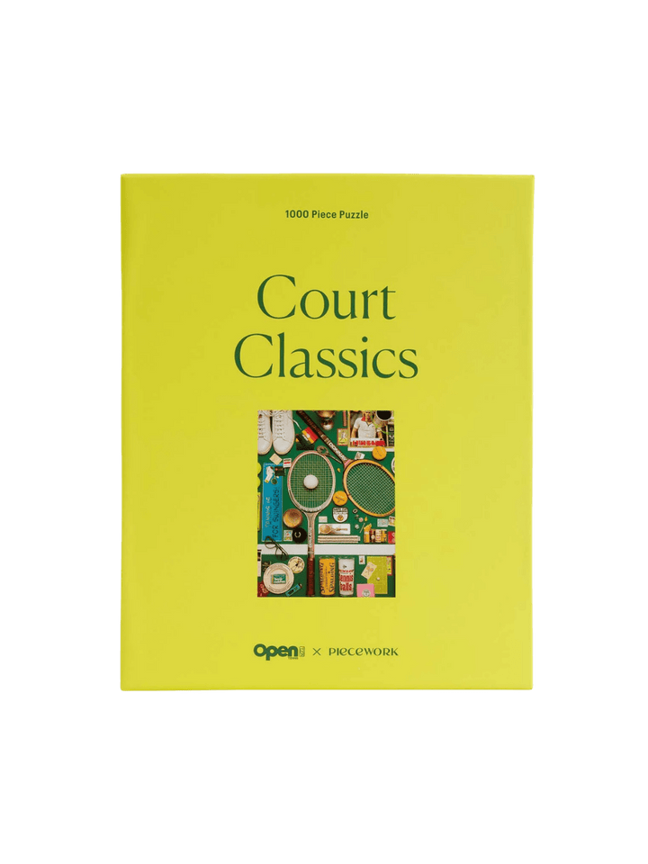 A vibrant yellow rectangular box of the Court Classics 1000 Piece Puzzle from Piecework Puzzles against a transparent background | Twentyseven Toronto