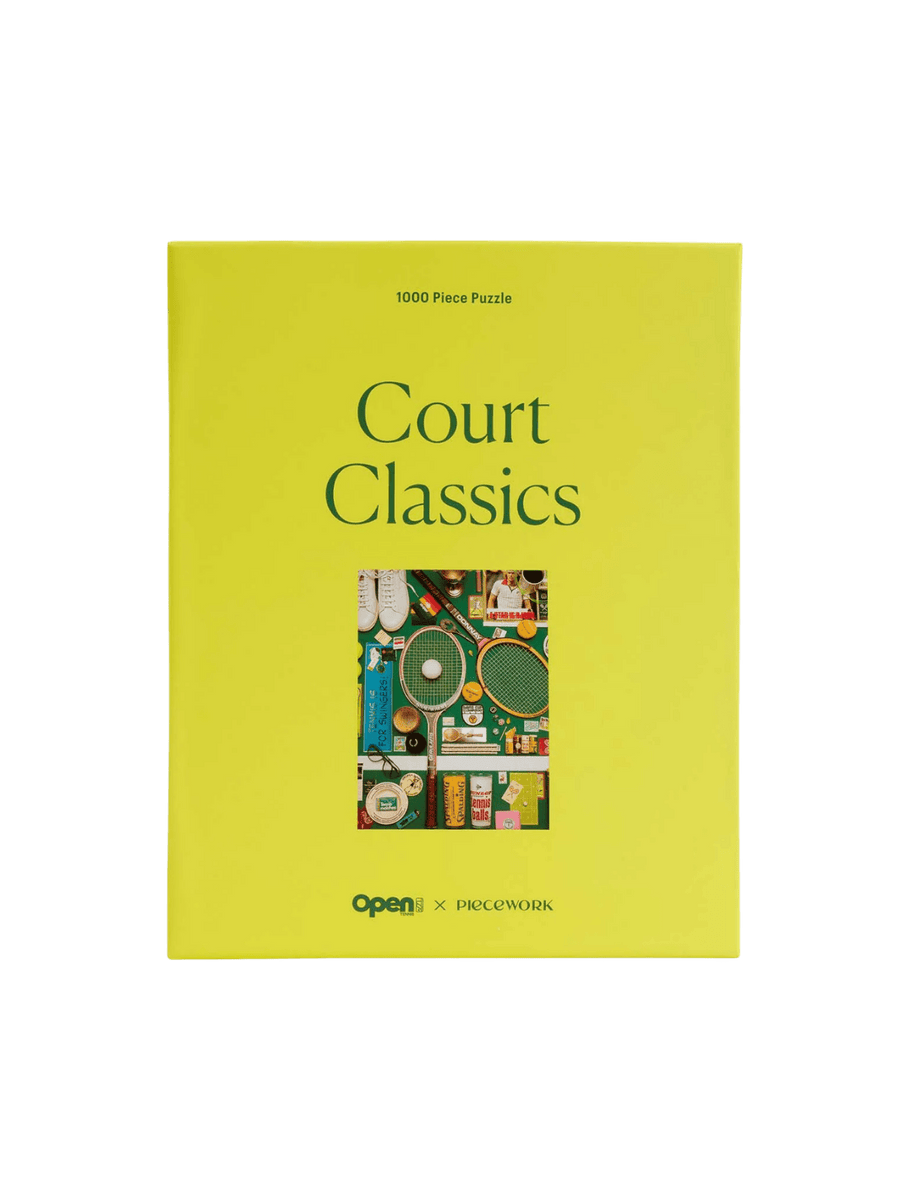 A vibrant yellow rectangular box of the Court Classics 1000 Piece Puzzle from Piecework Puzzles against a transparent background | Twentyseven Toronto