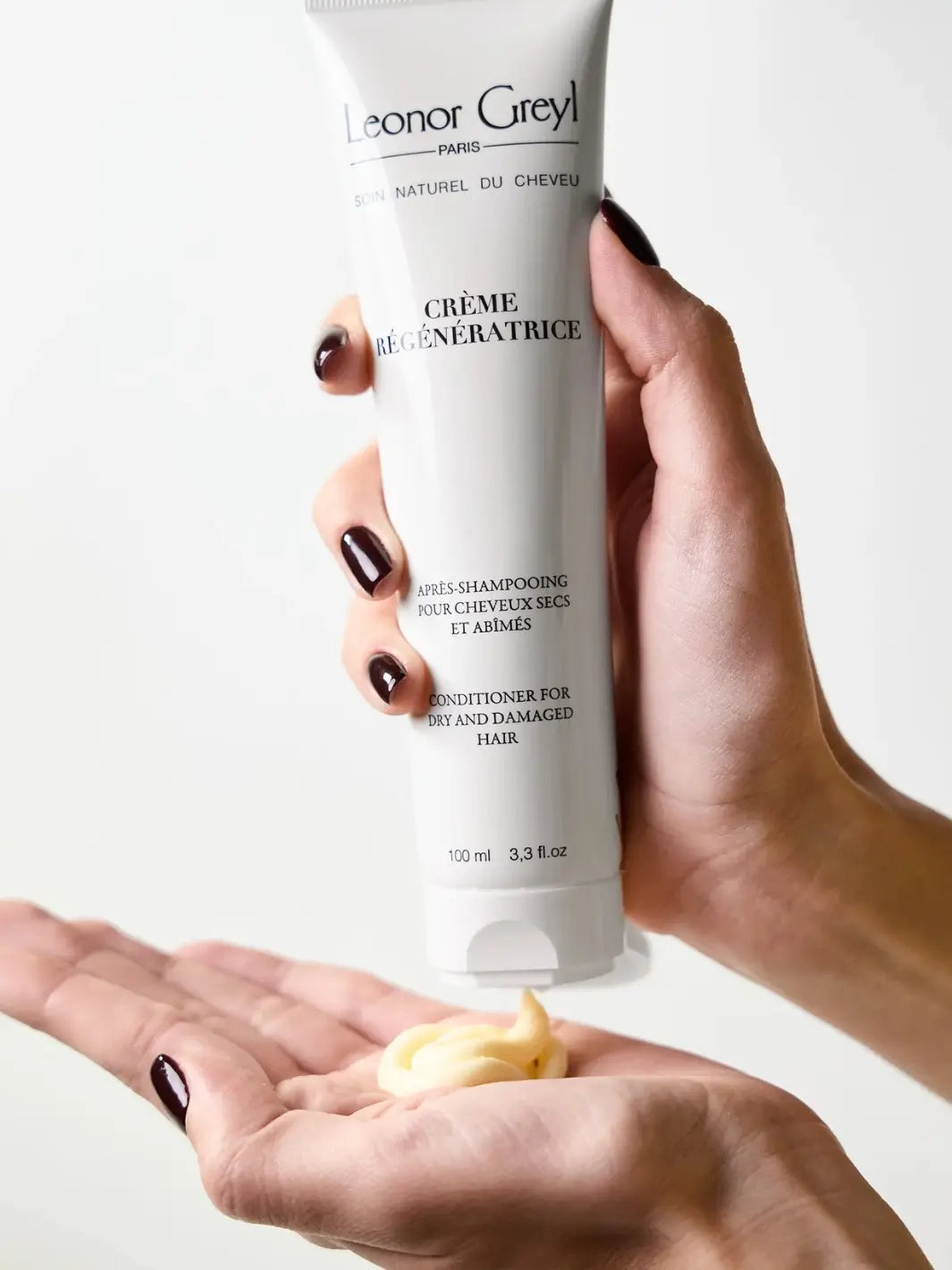 Hand holding a 100ml tube of Leonor Greyl 'Crème Régénératrice' with visible cream on palm | Twentyseven Toronto
