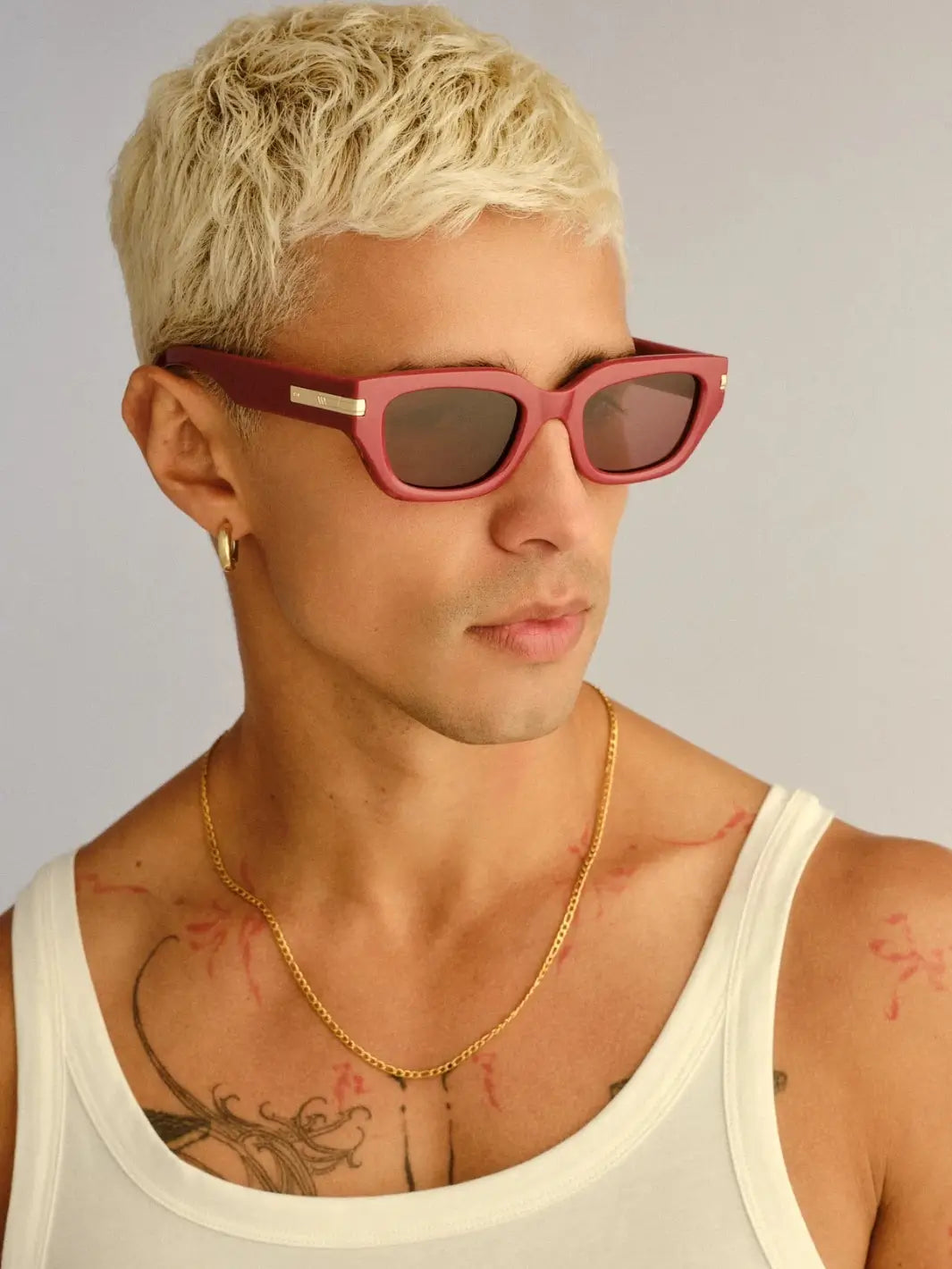 A portrait of a blonde man looking off-camera to the side while wearing the Le Specs Cubito + | Burgundy sunglasses | Twentyseven Toronto | Twentyseven Toronto