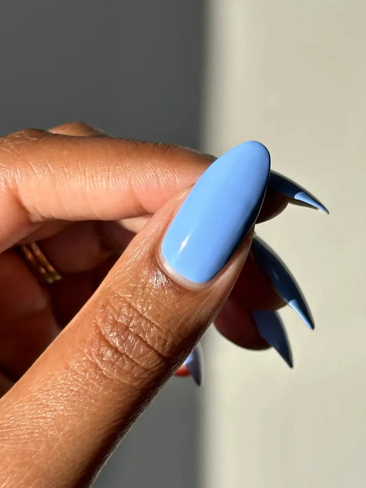 An extreme close-up focuses on a single long, pointed fingernail painted with light blue Death Valley Nails Curiosity Cloud Nail Polish | Twentyseven Toronto
