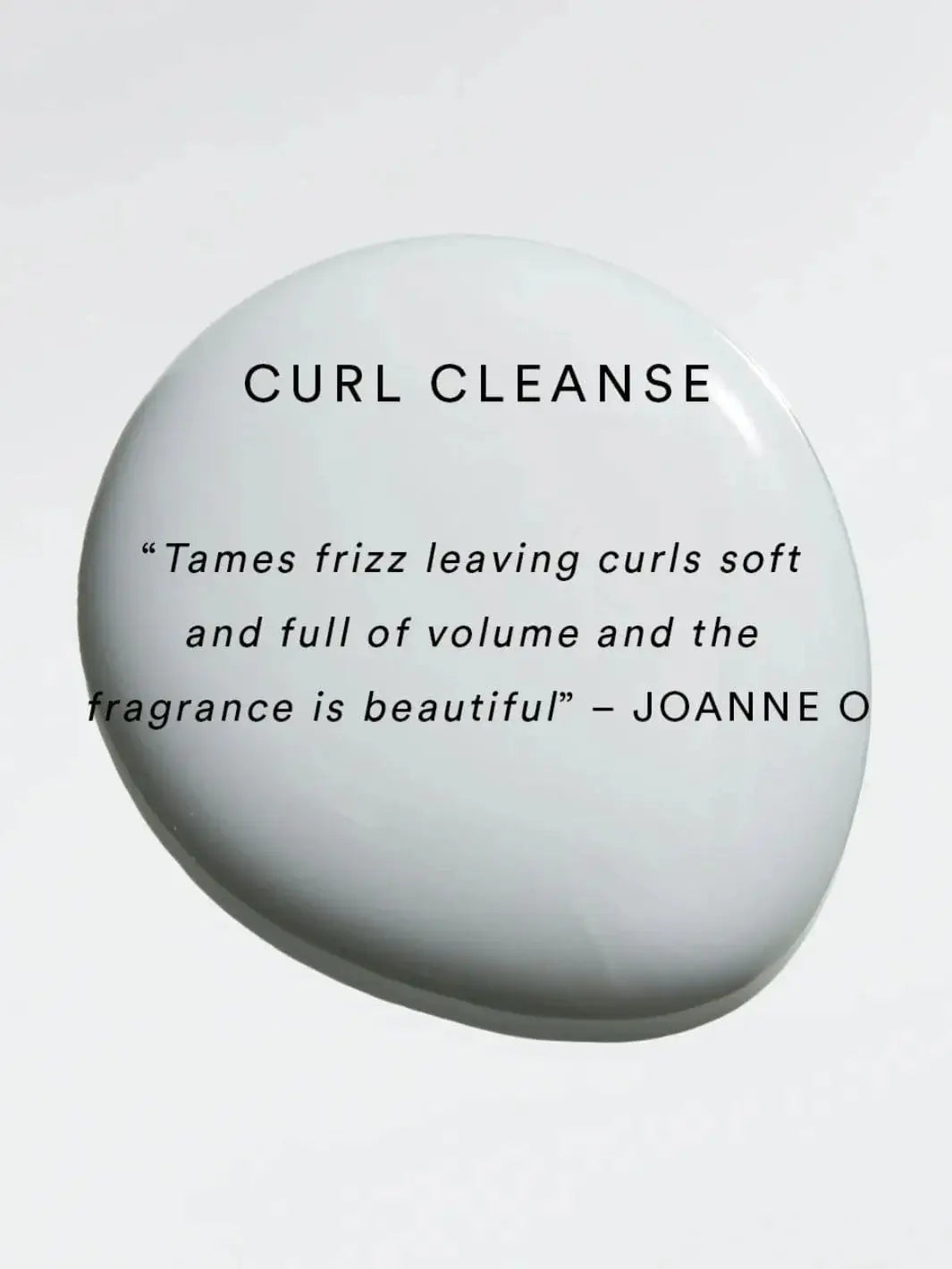 A white droplet of product serves as the background for a positive user review praising the frizz-taming abilities and beautiful fragrance of Hair by Sam McKnight Curl Cleanse Cleansing Conditioner | Twentyseven Toronto