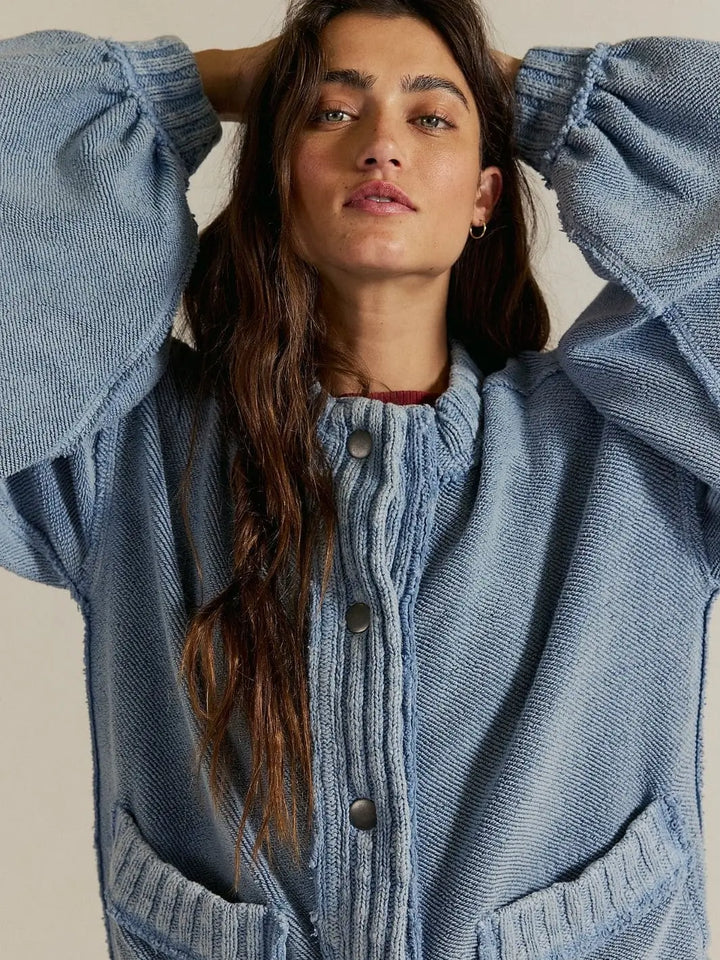 A close-up shot highlights the mock neckline, heavy snap-button placket, and cozy ribbed trim of the Free People Cute In This Cardi - Dusty Blue | Twentyseven Toronto