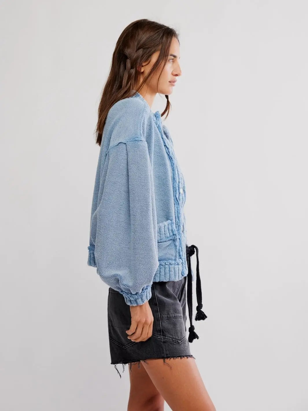 A side profile view displays the voluminous lantern sleeves and relaxed silhouette of the knit Free People Cute In This Cardi - Dusty Blue | Twentyseven Toronto