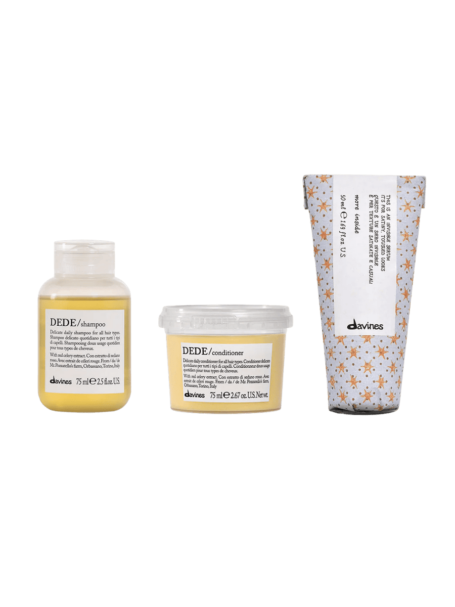 Three travel sized Davines hair care products including DEDE Shampoo, DEDE Conditioner (250ml) and This is an Invisible Serum (50ml) on a transparent background | Twentyseven Toronto