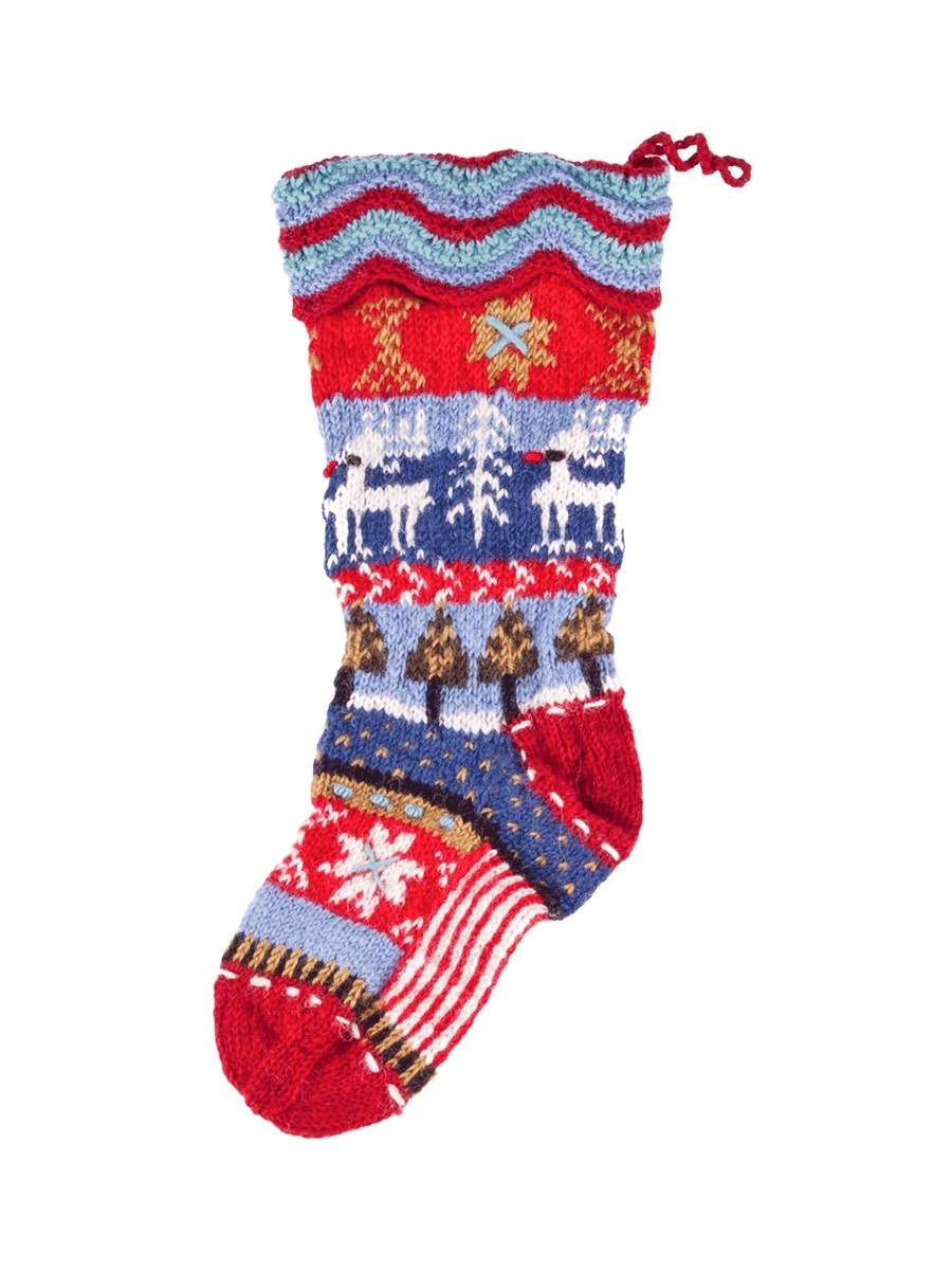 Lost Horizons Canada Dalarna hand-knit wool Christmas stocking featuring white reindeer, pine trees and snowflakes in red and blue, with a wavy knit cuff | Twentyseven Toronto