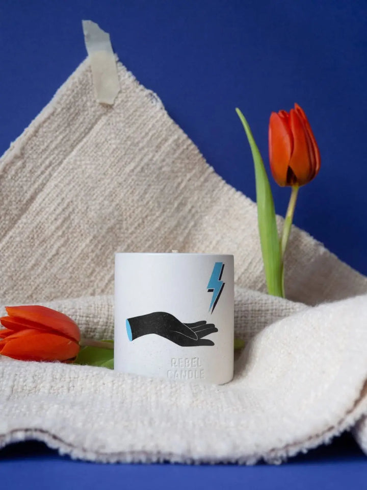 Maison Matine Dark and Stormy Scented Candle with a hand and lightning bolt design on a towel with tulips 160g | Twentyseven Toronto